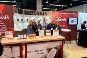 Smirk's team standing inside the Smirk's ExpoWest booth
